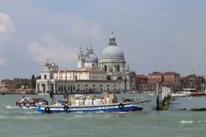Real photograph of a freight transport boat carrying goods through Venice, illustrating the city's car-free logistics