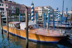 Classic wooden Venetian motorboat cruising along the Grand Canal near Rialto Bridge, a private way to explore Venice